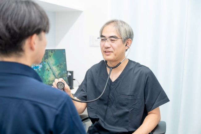 診察を行う院長